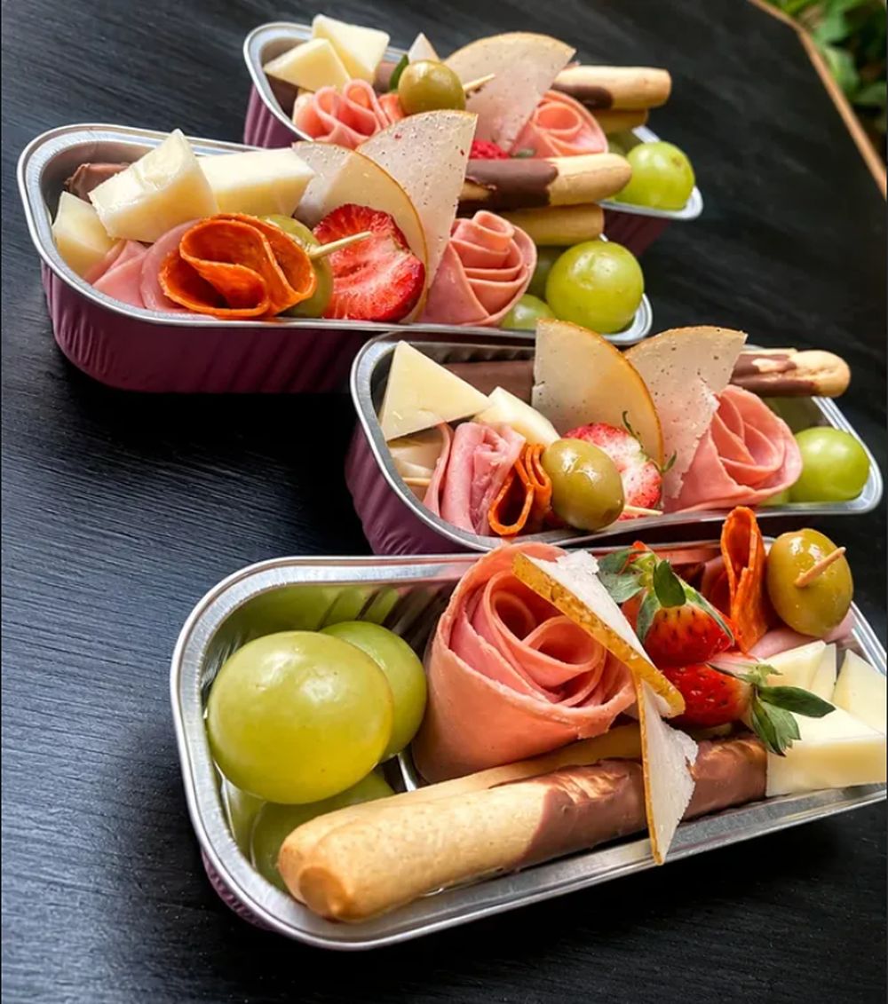 Mini charcuterías de Explosión de Sabor con jamón, queso, uvas y fresas para eventos
